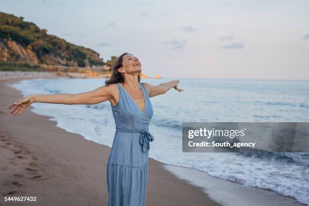 woman enjoying by the sea - female 40 year old beach stock pictures, royalty-free photos & images