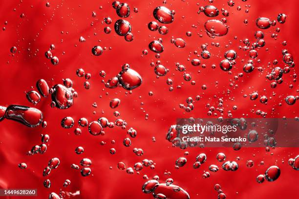 close up macro aloe vera gel cosmetic texture red background with bubbles. - acid stock pictures, royalty-free photos & images