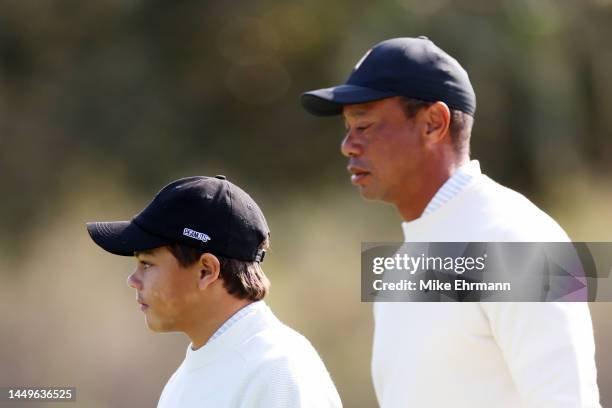 Charlie Woods and Tiger Woods of the United States walk on the 11th green during the pro-am prior to the PNC Championship at Ritz-Carlton Golf Club...