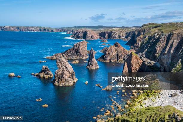 Outcrops of rock rise from the brilliant blue sea.