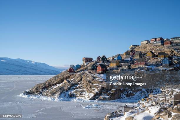 Colourful houses clinging to the edge of the mountain at Uummannaq in west Greenland.