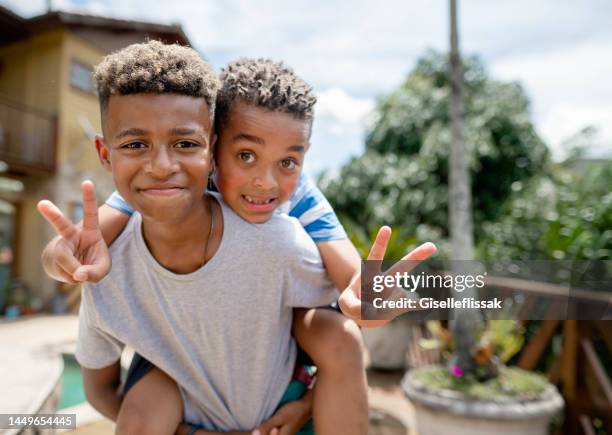 smiling young brothers playing together outside in summer - hand gestures stock pictures, royalty-free photos & images