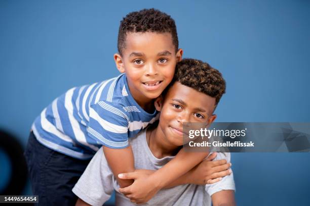 smiling young boy hugging his older brother at home - only boys photos stockfoto's en -beelden