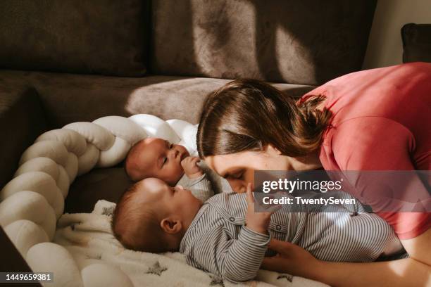 happy mother with her twins - twin brothers kissing stock pictures, royalty-free photos & images