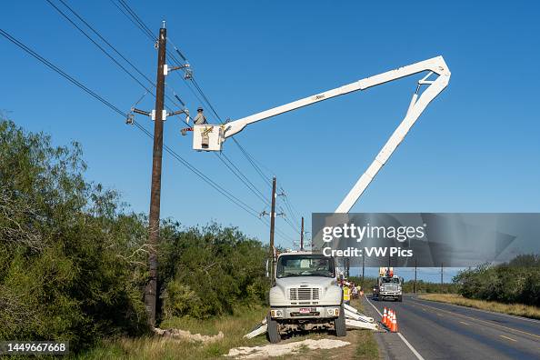 An electrical construction worker or lineman working in an elevated bucket to string new electrical transmission lines An electrical construction worker or lineman working in an elevated bucket to string new electrical transmission lines