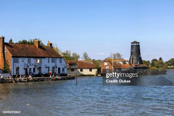 England, Hampshire, Langstone, Chichester Harbour, View of The Royal Oak Pub and Customers at High Tide.