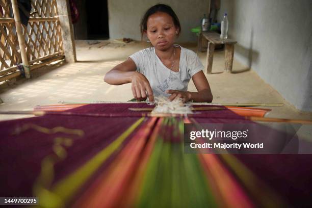 Tribal woman weaving 'Rignawi', a traditional cloth used by the tribes of Tripura, in Tirthamoni village. Agartala, Tripura, India.