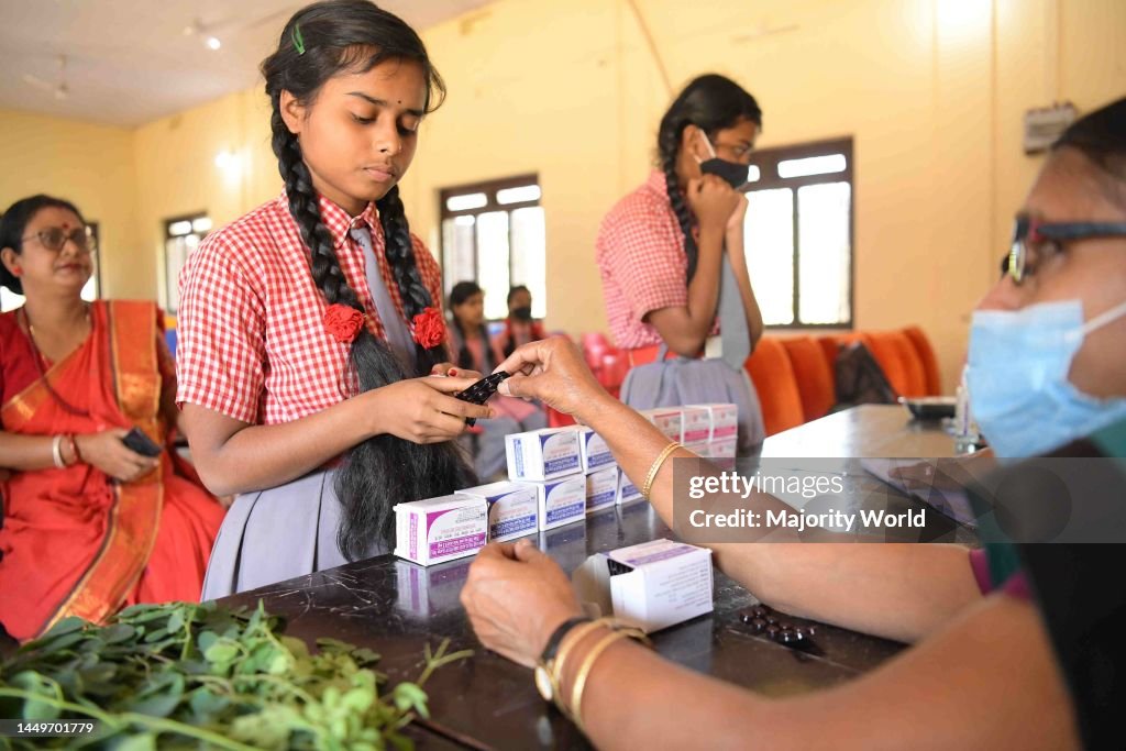 A health worker provides medicine to the students for anemia