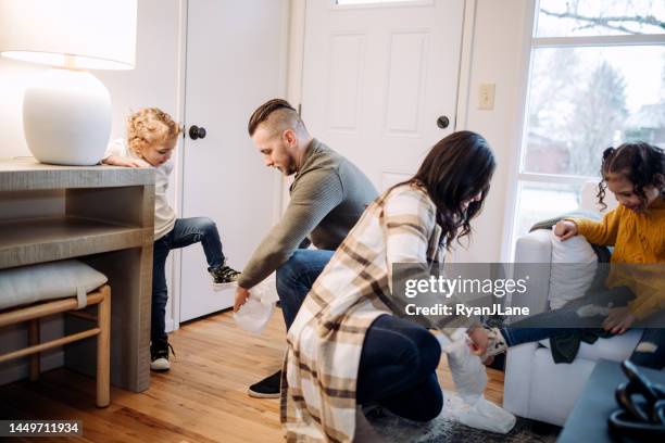 family at real estate home viewing puts on shoe covers - shoe covers stock pictures, royalty-free photos & images