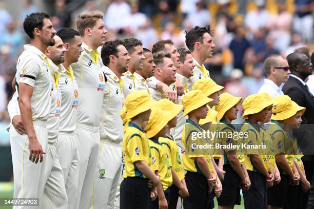 Members of Team Australia stand and sing the national anthem during day one of the First Test match between Australia and South Africa at The Gabba...