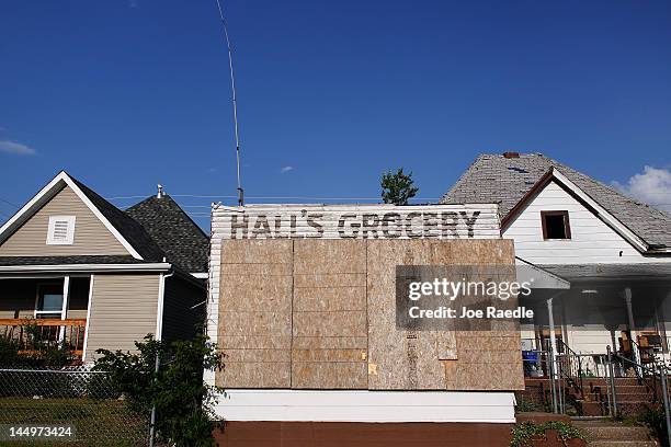 As the one year anniversary of the massive tornado hitting the town approaches a damaged grocery store is seen next to a home that has been rebuilt...