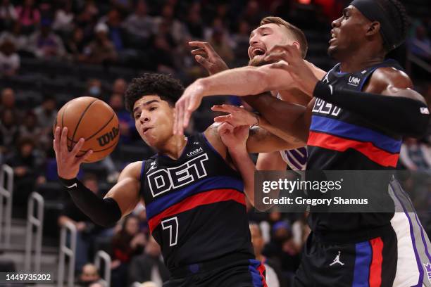 Killian Hayes of the Detroit Pistons grabs a first half rebound against Domantas Sabonis of the Sacramento Kings at Little Caesars Arena on December...