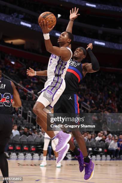 De'Aaron Fox of the Sacramento Kings drives to the basket in front of Jalen Duren of the Detroit Pistons during the first half at Little Caesars...