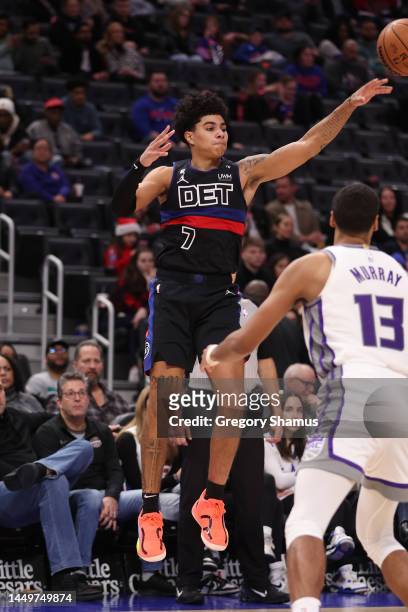 Killian Hayes of the Detroit Pistons passes around Keegan Murray of the Sacramento Kings during the second half at Little Caesars Arena on December...