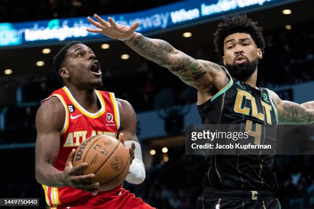Aaron Holiday of the Atlanta Hawks drives to the basket while guarded by Nick Richards of the Charlotte Hornets in the fourth quarter during their...