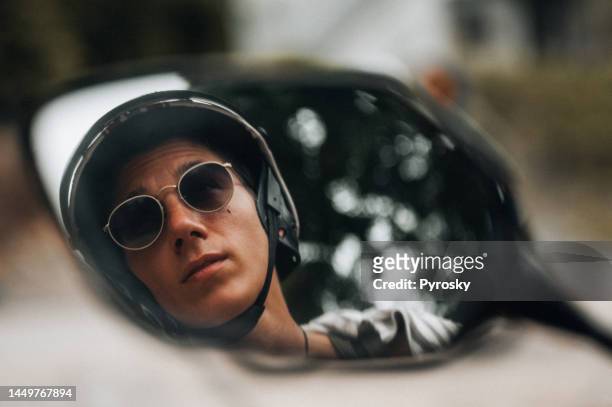 riflesso di un giovane nello specchietto retrovisore di una motocicletta - motor scooter foto e immagini stock
