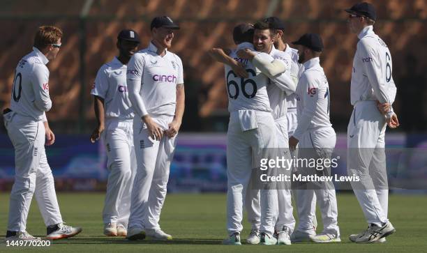 Joe Root of England congratulates Mark Wood of England on the wicket of Shan Masood of Pakistan during day one of the Third Test match between...