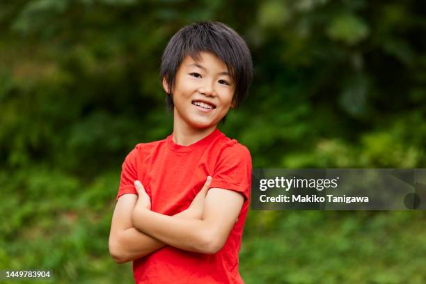 portrait of a japanese boy, in a park - smiling boy in tshirt stockfoto's en -beelden