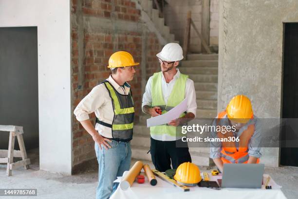 three engineers coordinate to plan and discuss problems related to the construction on the construction site. - construction consulting stock pictures, royalty-free photos & images