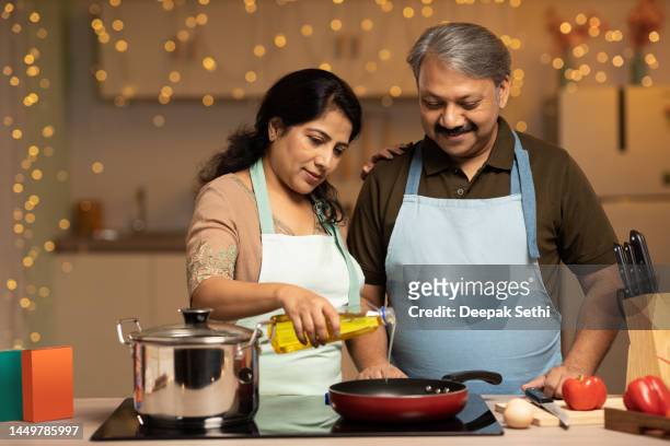 smiling couple preparing food at home stock photo - house warm heating oil stockfoto's en -beelden