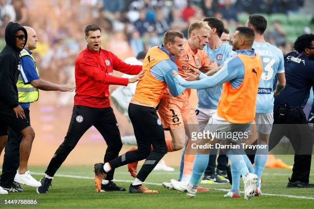 Bleeding Tom Glover of Melbourne City is escorted from the pitch by team mates after fans stormed the pitch during the round eight A-League Men's...