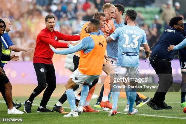 Bleeding Tom Glover of Melbourne City is escorted from the pitch by team mates after fans stormed the pitch during the round eight A-League Men's...