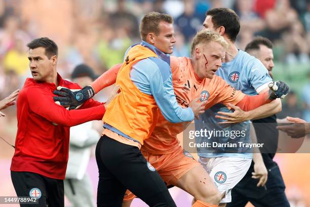 Bleeding Tom Glover of Melbourne City is escorted from the pitch by team mates after fans stormed the pitch during the round eight A-League Men's...