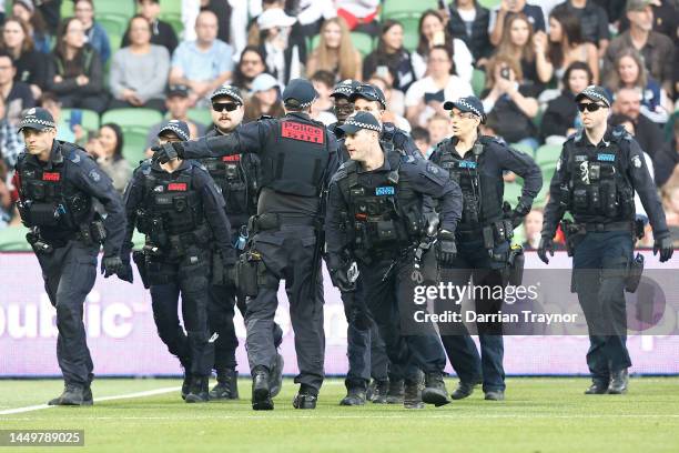 Members of Victoria Police are seen on the pitch after fans stormed the ground in protest during the round eight A-League Men's match between...