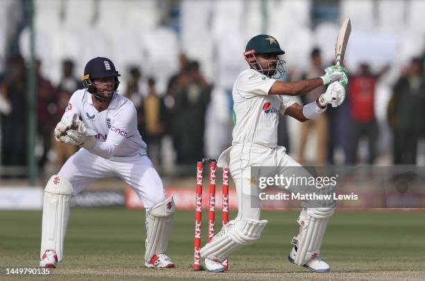 Babar Azam of Pakistan hits the ball towards the boundary, as Ben Foakes of England watches on during day one of the Third Test match between...