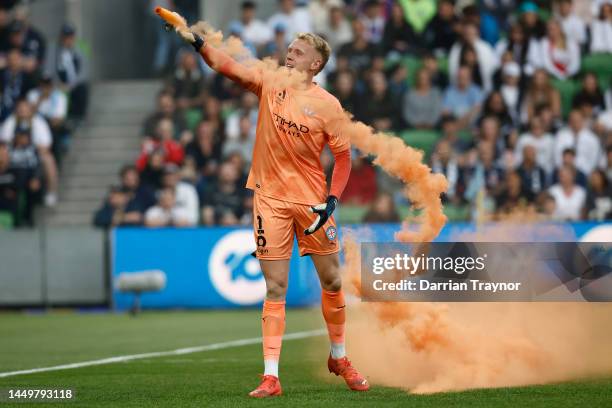 Tom Glover of Melbourne City picks up a flare to remove it from the pitch during the round eight A-League Men's match between Melbourne City and...