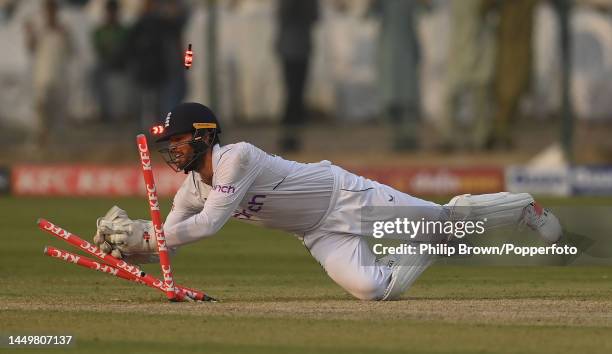 Ben Foakes of England breaks the stumps in a run out attempt during the first day of the third Test between Pakistan and England at Karachi National...