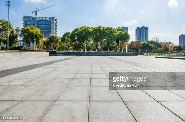 on the other side of the lake, there are many tall buildings in the business district and a stone platform beside the lake. wuxi, jiangsu province, china. - street footpath stock pictures, royalty-free photos & images