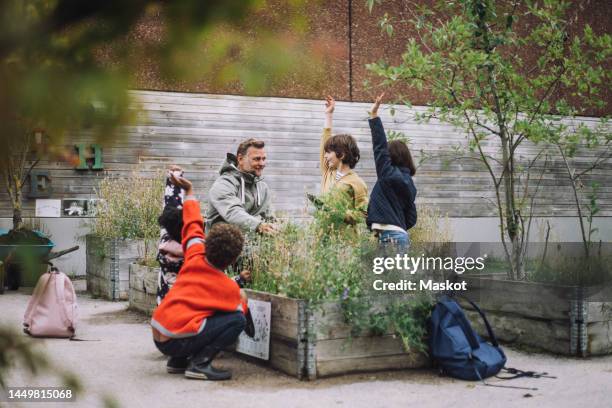 teacher doing q and a session with male and female students in school garden - sweden school stock pictures, royalty-free photos & images