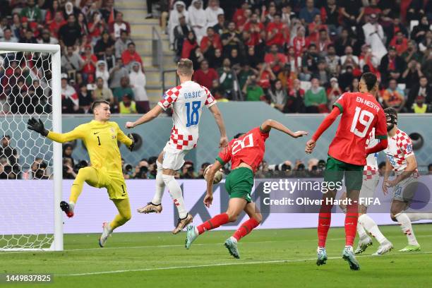 Achraf Dari of Morocco scores the team's first goal as Dominik Livakovic of Croatia attempts to make a save during the FIFA World Cup Qatar 2022 3rd...