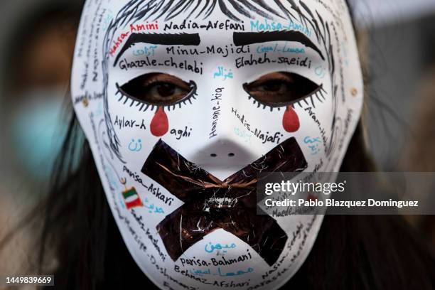 Woman wears a mask with the names of Iranian government's victims during a protest against the executions of protesters in Iran, outside the Iranian...