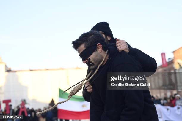 Man holds a man with a noose around his neck in honor of the lives of Iranian Women on December 17, 2022 in Turin, Italy. In the first known...