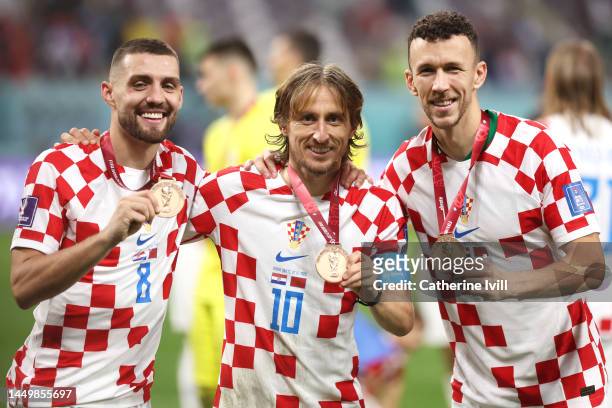 Mateo Kovacic, Luka Modric and Ivan Perisic of Croatia celebrate with their FIFA World Cup Qatar 2022 third placed medals after the team's victory...