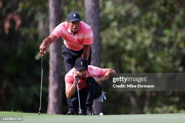 Tiger Woods of the United States and son Charlie Woods line up a putt on the first green during the first round of the PNC Championship at...