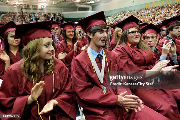 Quinton Anderson, middle, who was nearly killed in the tornado that ravaged Joplin a year ago, blushes as President Barack Obama retells his story of...