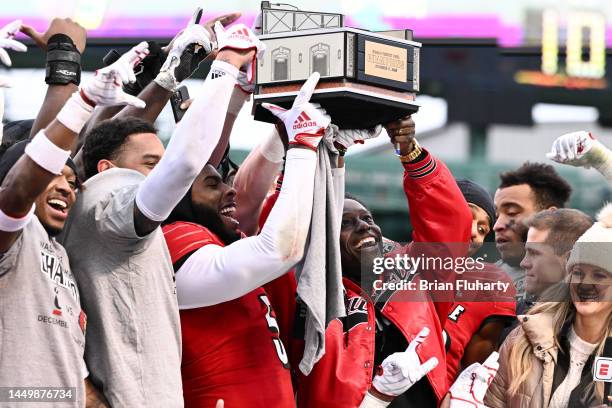 Interim head coach Deion Branch of the Louisville Cardinals and tight end Marshon Ford hold up the Wasabi Fenway Bowl after the Cardinals defeated...