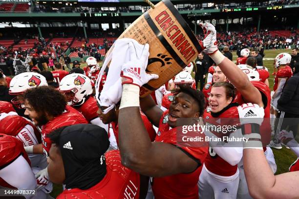 Defensive lineman YaYa Diaby of the Louisville Cardinals holds up the Keg of Nails Trophy after defeating the Cincinnati Bearcats in the Wasabi...