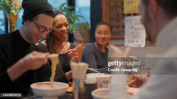 grupo de amigos multirraciales de turistas disfrutando de experimentar y tener comida japonesa ramen en la tienda de ramen - ramen noodles fotografías e imágenes de stock