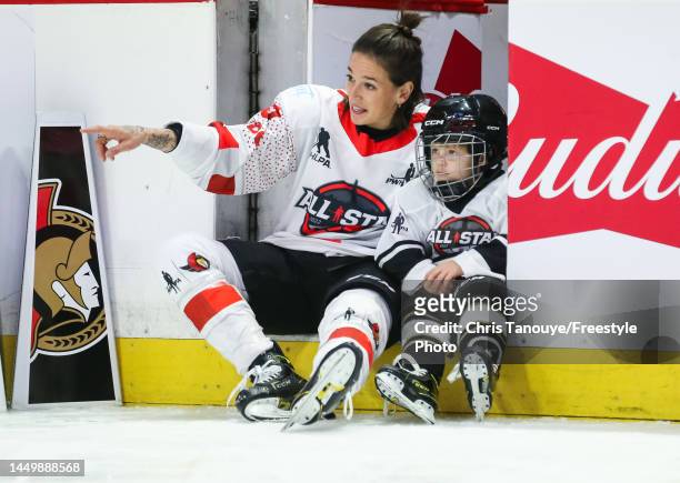 Mélodie Daoust of Team Keller watches the PWHPA All-Star Game and Skills Competition with her son at Canadian Tire Centre on December 11, 2022 in...