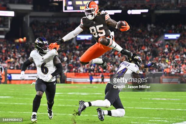 David Njoku of the Cleveland Browns leaps following his reception as Marlon Humphrey and Patrick Queen of the Baltimore Ravens attempt a tackle...