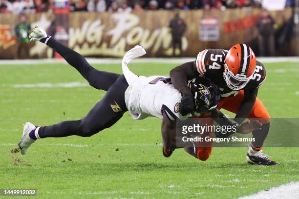 Tyler Huntley of the Baltimore Ravens is tackled by Deion Jones of the Cleveland Browns during the third quarter at FirstEnergy Stadium on December...
