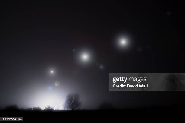 glowing alien ufo lights floating in the sky. on a spooky foggy winters night - disco volante foto e immagini stock