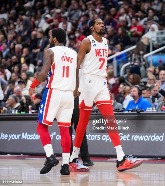 Kyrie Irving and Kevin Durant of the Brooklyn Nets slap hands against the Toronto Raptors during the second half of their basketball game at the...