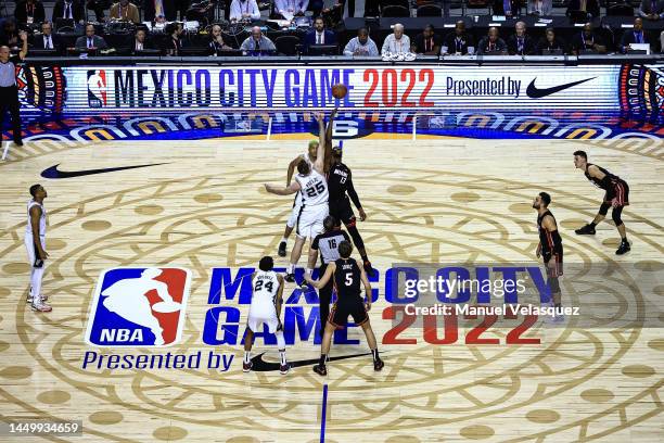 Jakob Poeltl of the San Antonio Spurs and Bam Adebayo of the Miami Heat jump for the ball during the game between San Antonio Spurs against Miami...