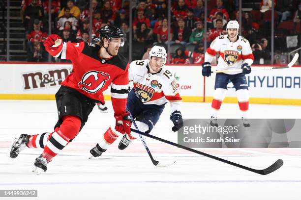 Dougie Hamilton of the New Jersey Devils and Matthew Tkachuk of the Florida Panthers chase the puck during the first period at Prudential Center on...