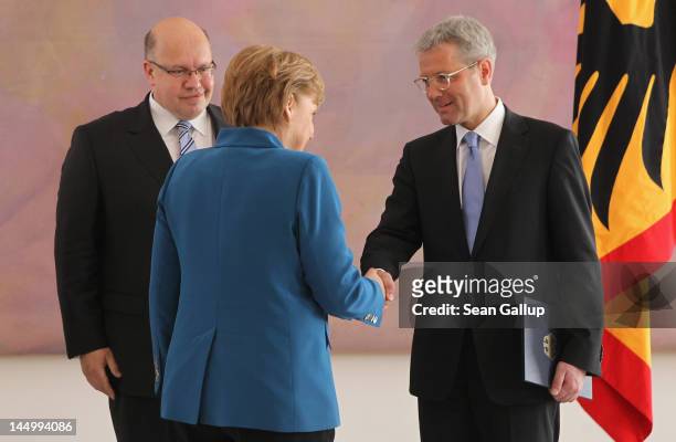 German Chancellor Angela Merkel shakes hands with outgoing German Minister of the Environment Norbert Roettgen after he received his discharge papers...